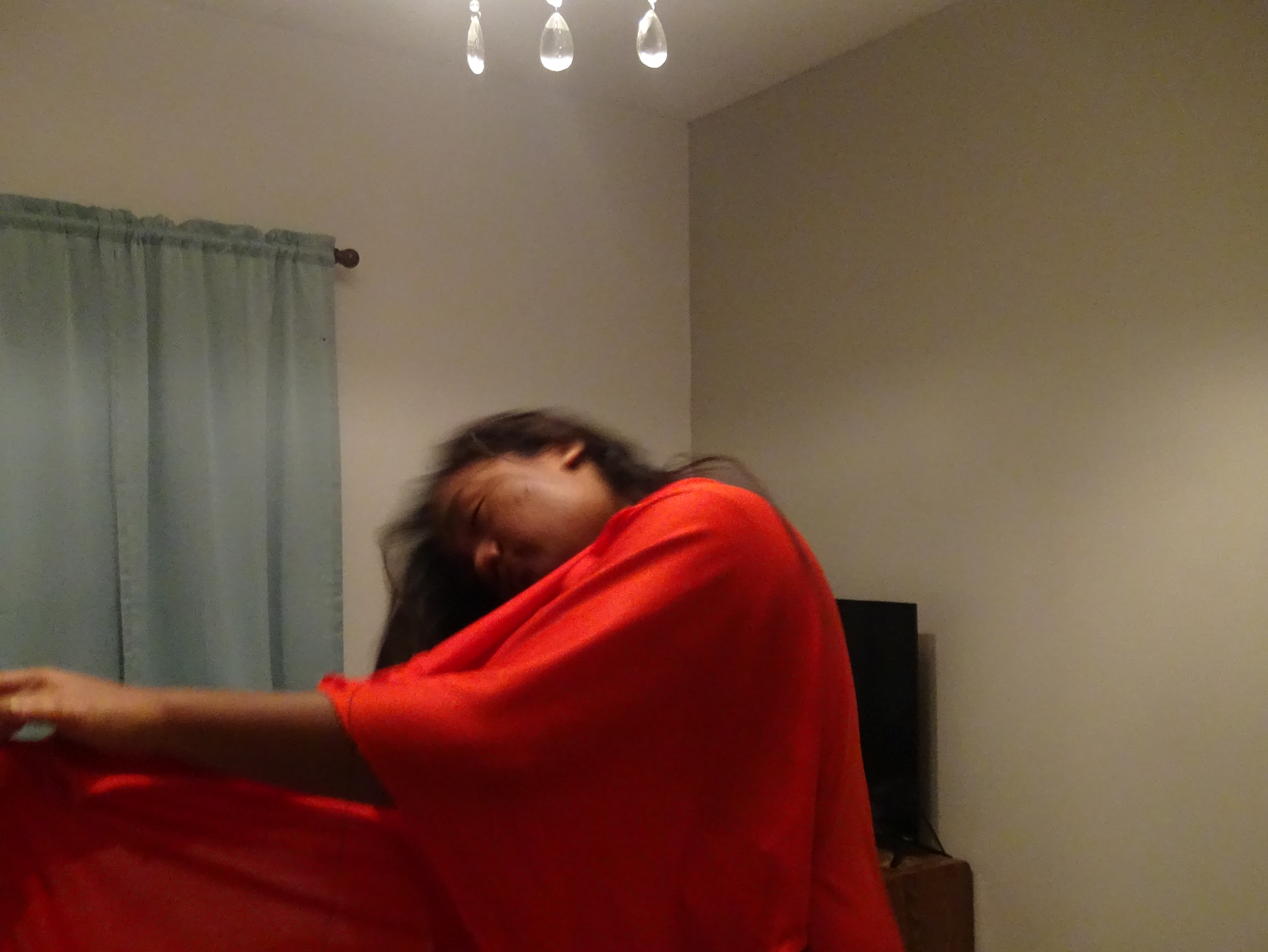 influencer and model elidae danh whipping her hair up while head is slightly down while sitting up