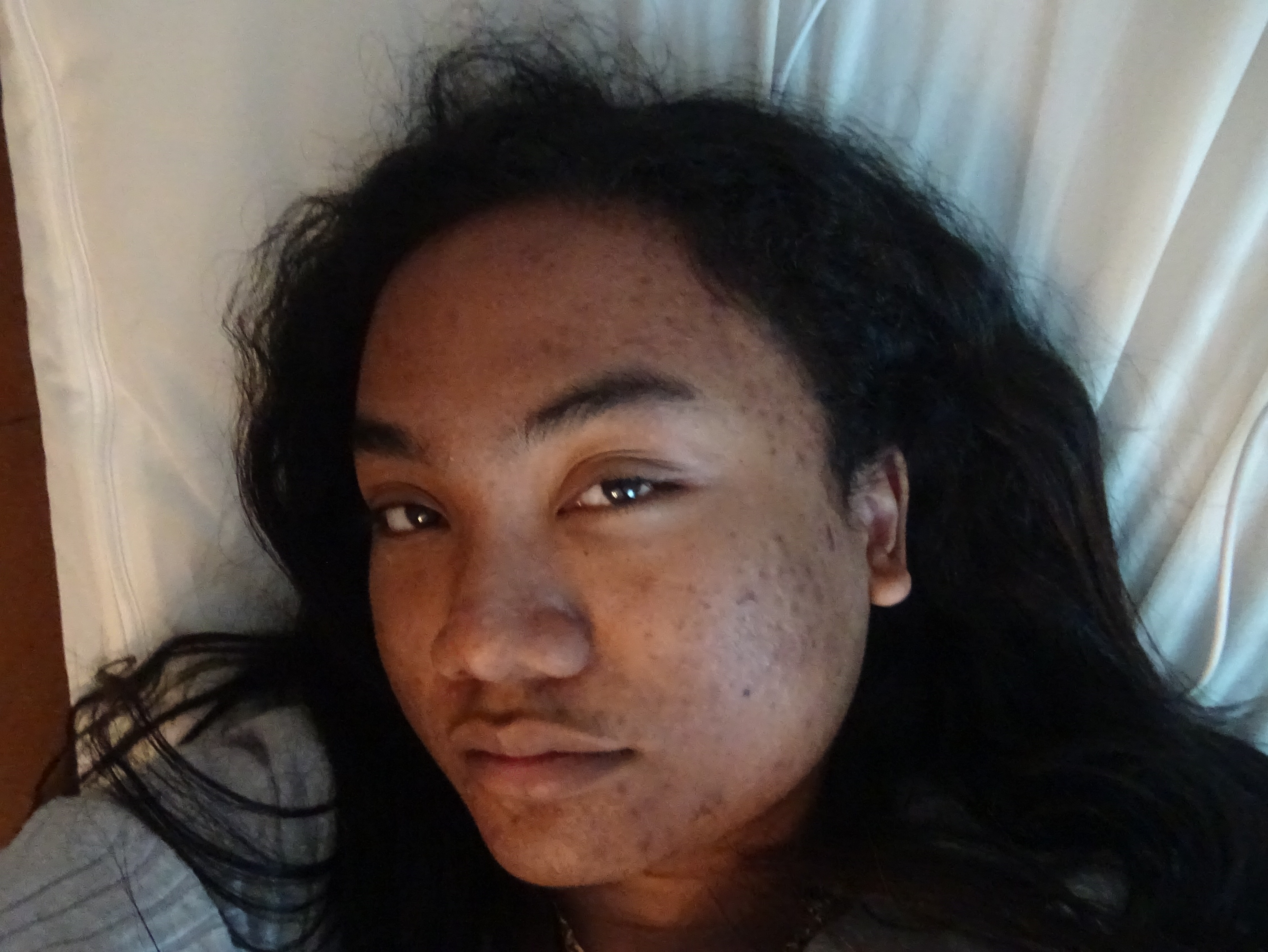 influencer and model elidae danh whipping her hair up while head is slightly down while sitting up